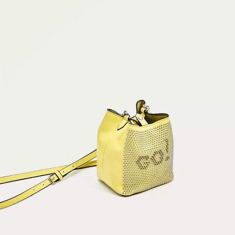 graphic studded yellow sling bag angle view edgability