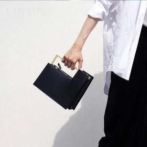 classy black bag formal clutch bag with gold handle edgability front view