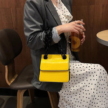 croc skin yellow sling bag with black strap edgability model view