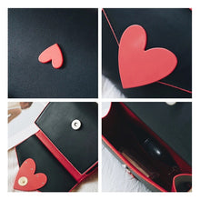detail views of red heart on black shoulder bag edgability