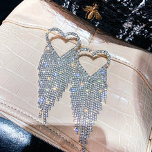 crystal studded heart shaped earrings with rhinestone tassels top view
