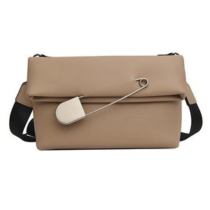 beige clutch bag with safety pin edgability